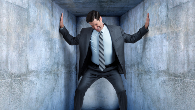 image shows man trapped in a box closing in on itself