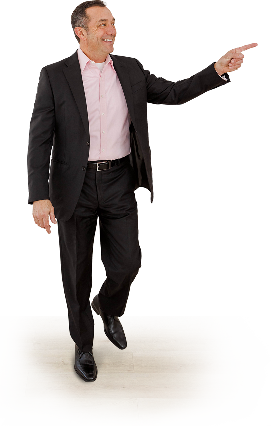 Image of Nathan Jamail Leadership and Sales Keynote Speaker in a charcoal suit and pink shirt walking and pointing off camera while smiling