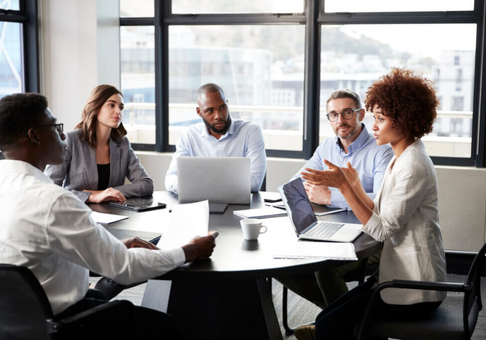 Millennial black businesswoman addressing colleagues at a corporate business meeting, close up